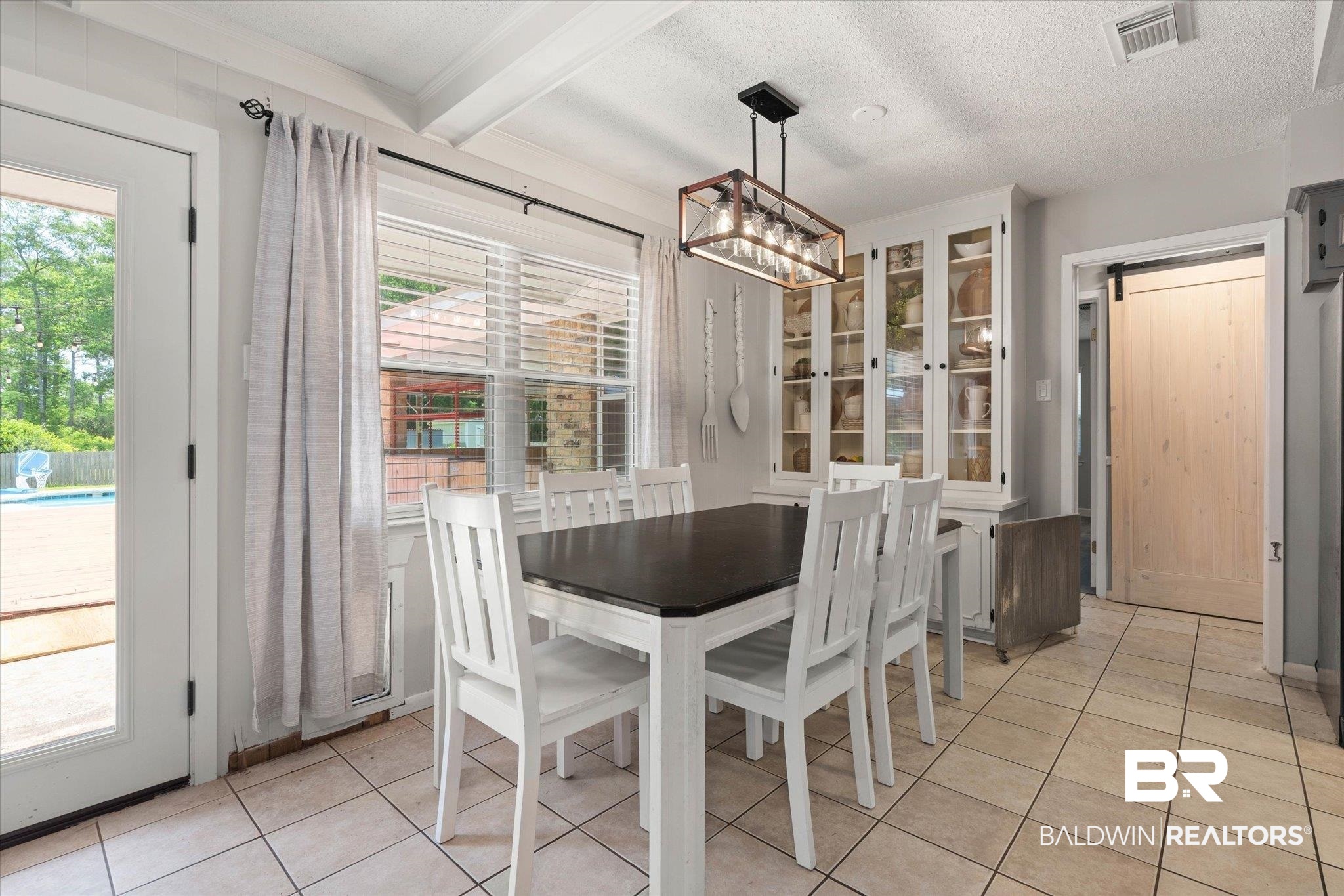 1025 Walter Smith Road Mobile, AL 36695 - Photo 7 of 46 Dining space featuring light tile patterned floors, beam ceiling, and a textured ceiling