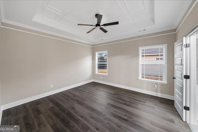 a view of empty room with wooden floor and ceiling fan