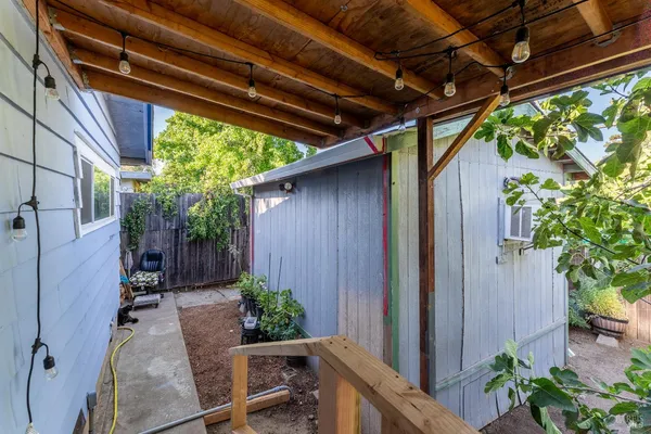 a backyard of a house with plants and outdoor seating
