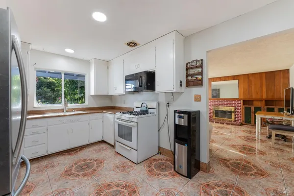 a kitchen with stainless steel appliances granite countertop a refrigerator a stove top oven a sink and dishwasher