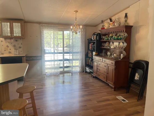 a open kitchen with a table chairs and a wooden floor