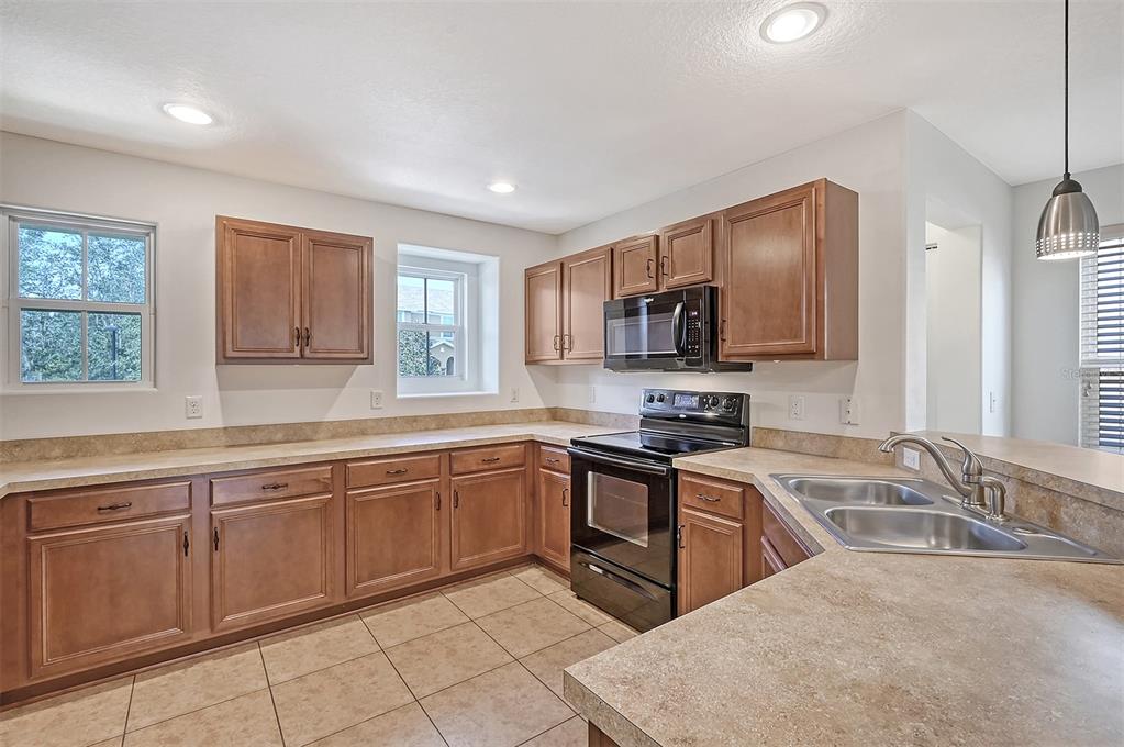8922 White Sage Loop Lakewood Ranch, FL 34202 - Photo 16 of 65 a kitchen with granite countertop a sink stainless steel appliances and cabinets