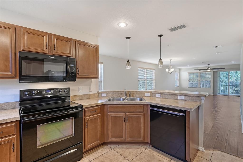 8922 White Sage Loop Lakewood Ranch, FL 34202 - Photo 18 of 65 a kitchen with stainless steel appliances granite countertop a stove microwave and sink