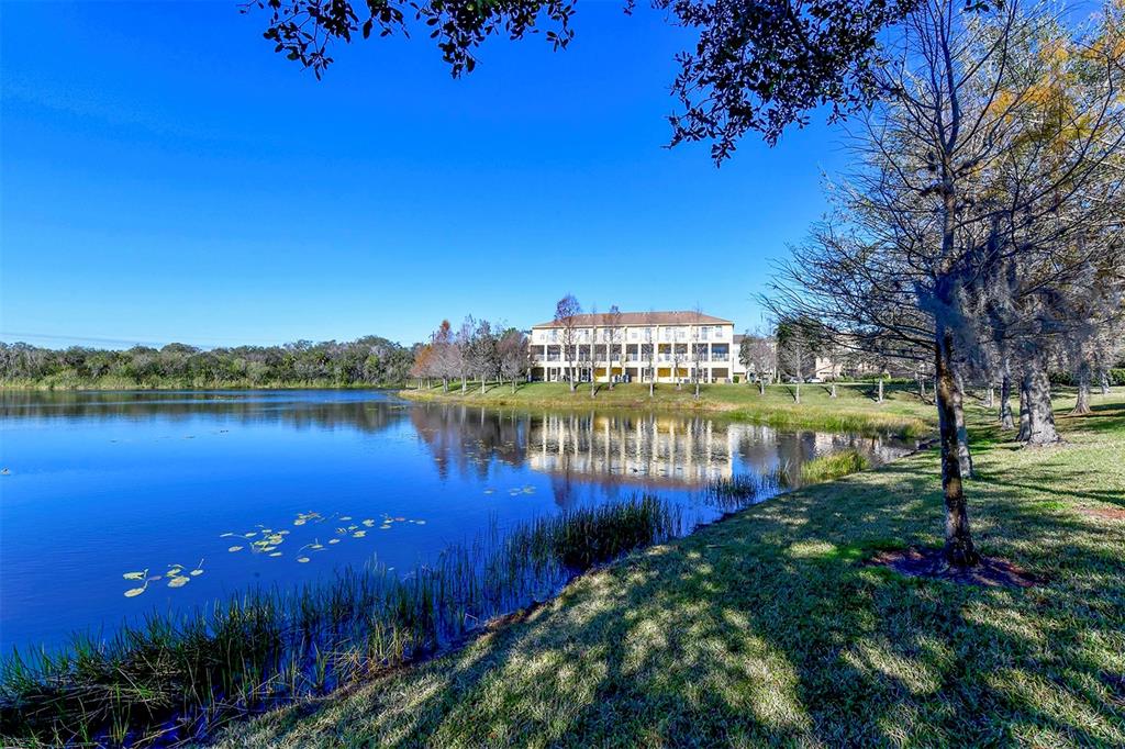 8922 White Sage Loop Lakewood Ranch, FL 34202 - Photo 63 of 65 a view of a lake with a building in the background