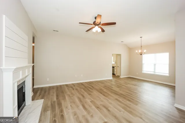 a view of empty room with wooden floor and fireplace