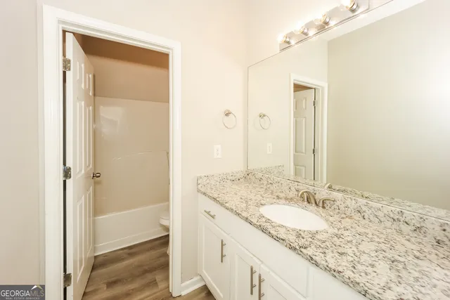 a bathroom with a granite countertop sink and a mirror