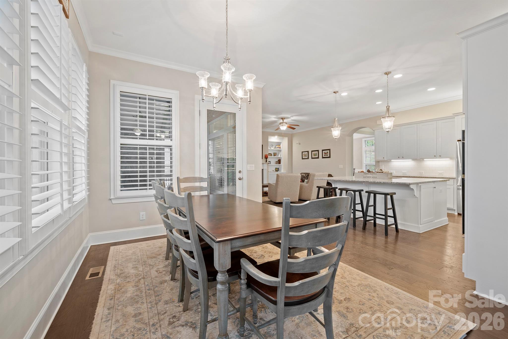 13044 Fen Court Huntersville, NC 28078 - Photo 15 of 43 a dining room with furniture a chandelier and wooden floor