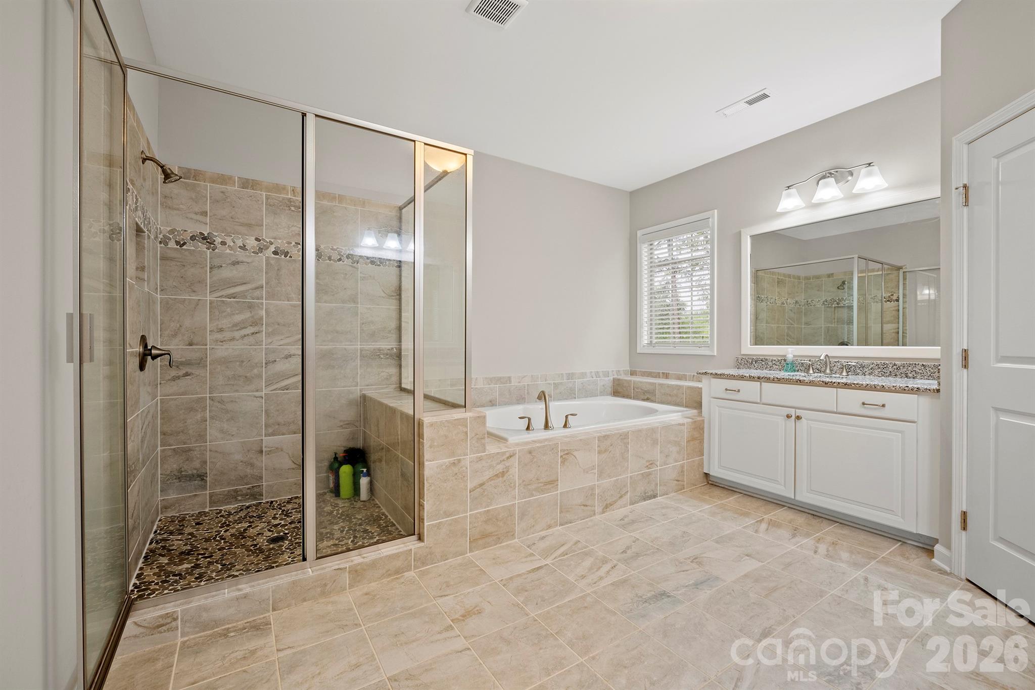 13044 Fen Court Huntersville, NC 28078 - Photo 25 of 43 a spacious bathroom with a granite countertop sink a toilet a mirror and shower