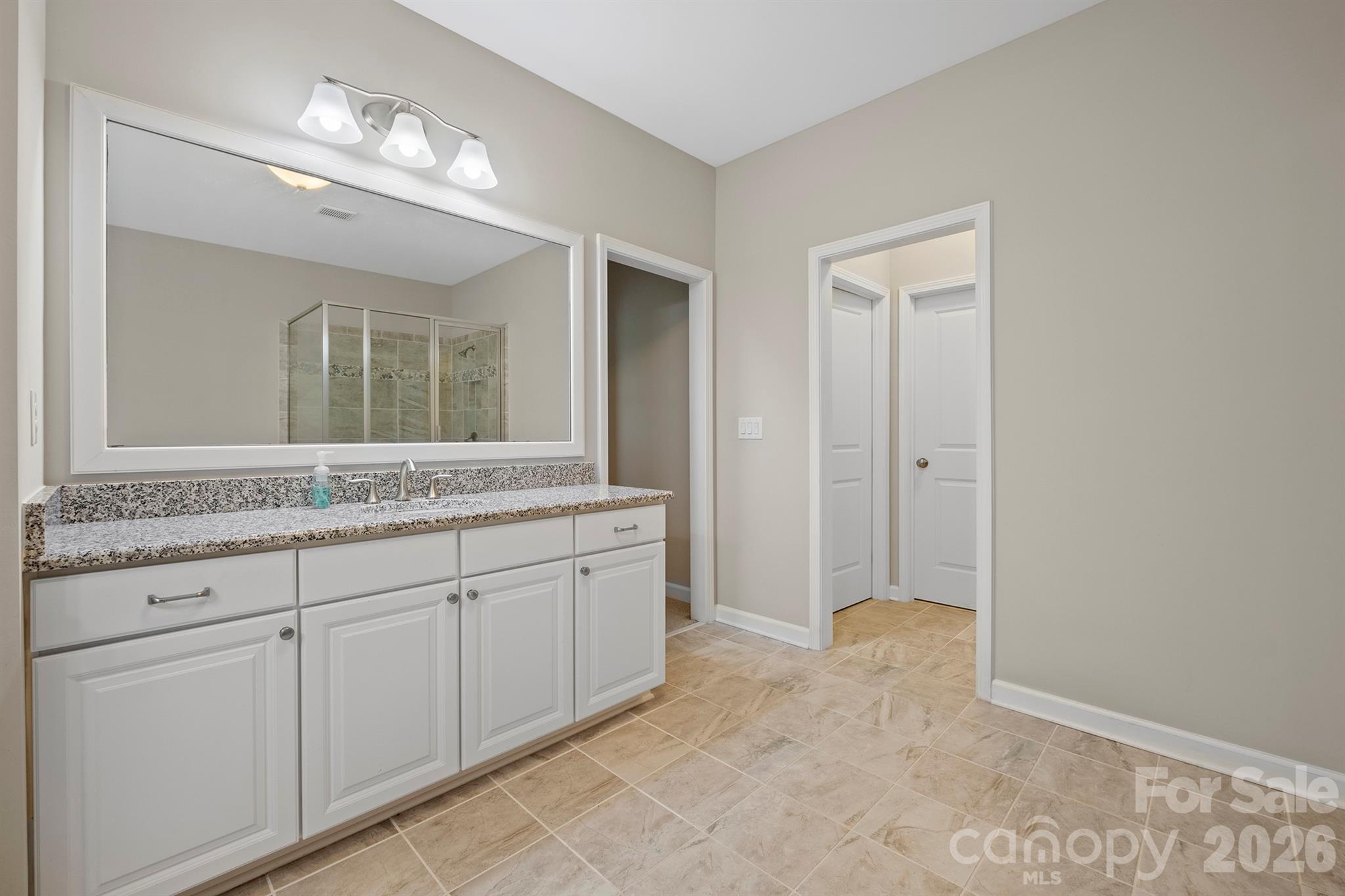 13044 Fen Court Huntersville, NC 28078 - Photo 27 of 43 a spacious bathroom with a granite countertop sink a mirror and a