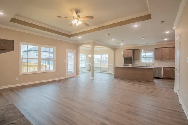 a view of an empty room with a kitchen and a window
