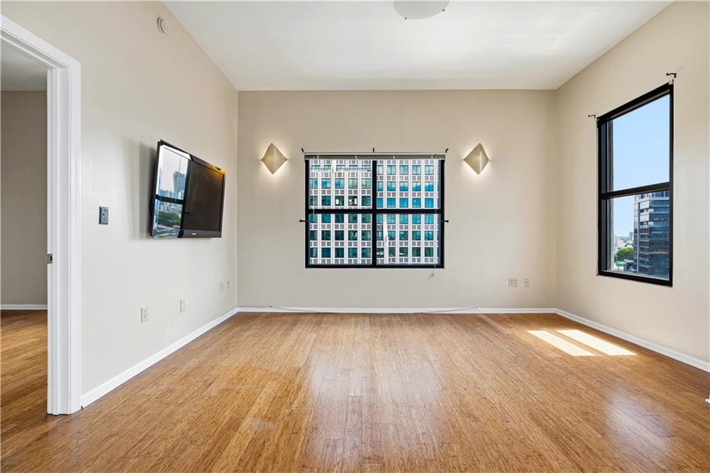 3040 Peachtree Road Northwest, Unit 1503 Atlanta, GA 30305 - Photo 5 of 38 a view of an empty room with wooden floor and a window