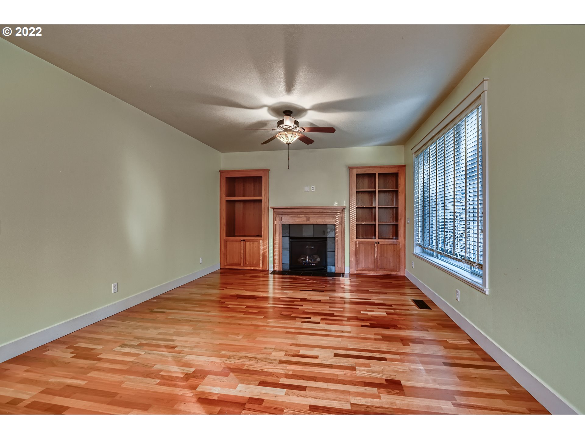 14656 Southwest 164th Avenue Tigard, OR 97224 - Photo 5 of 31 a view of a livingroom with a fireplace a ceiling fan and wooden floor