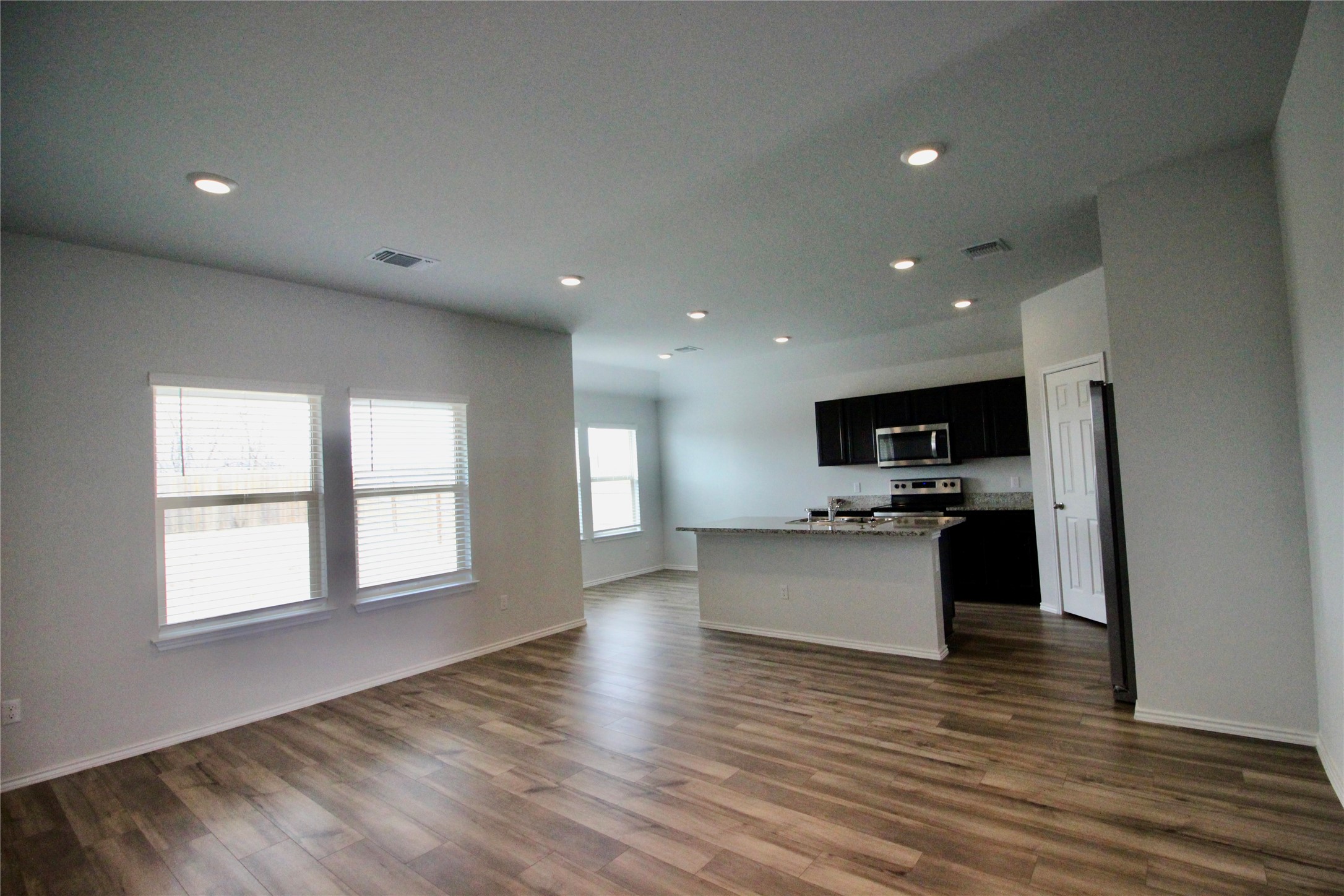 602 Wyatt Way Jarrell, TX 76537 - Photo 7 of 8 Kitchen with dark cabinets, open floor plan, a kitchen island with sink, stainless steel appliances, and dark wood finished floors
