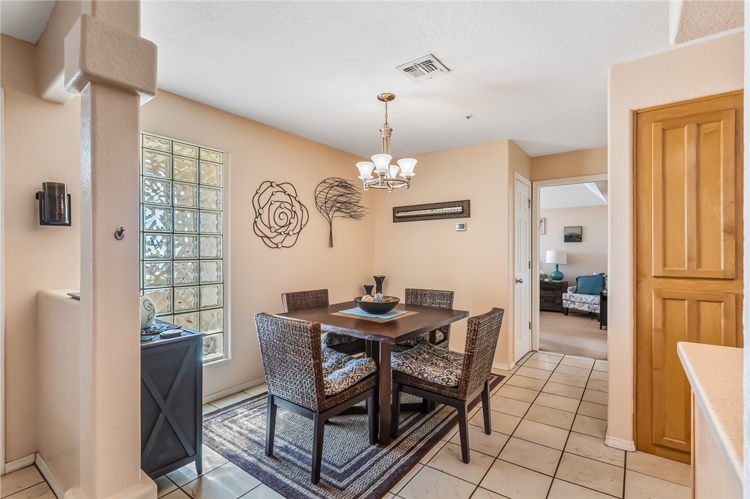 3408 Sunriver Road, Unit 208 Bullhead City, AZ 86429 - Photo 13 of 47 a dining room with furniture a chandelier and wooden floor