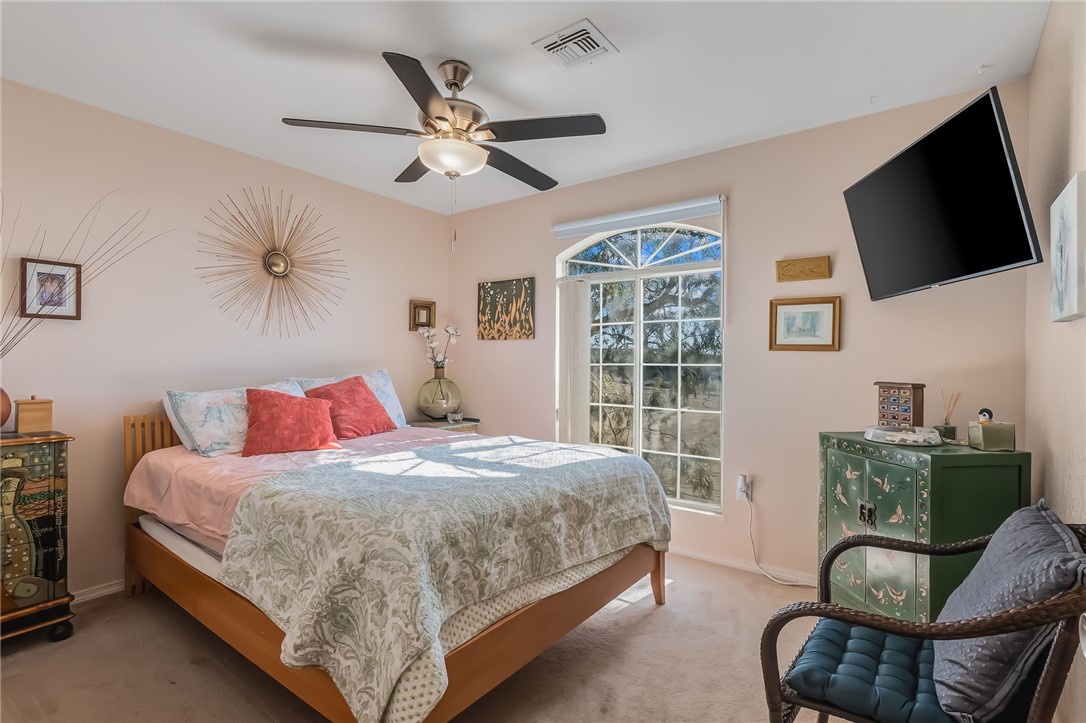 3408 Sunriver Road, Unit 208 Bullhead City, AZ 86429 - Photo 27 of 47 a bedroom with a bed a couch and a flat screen tv