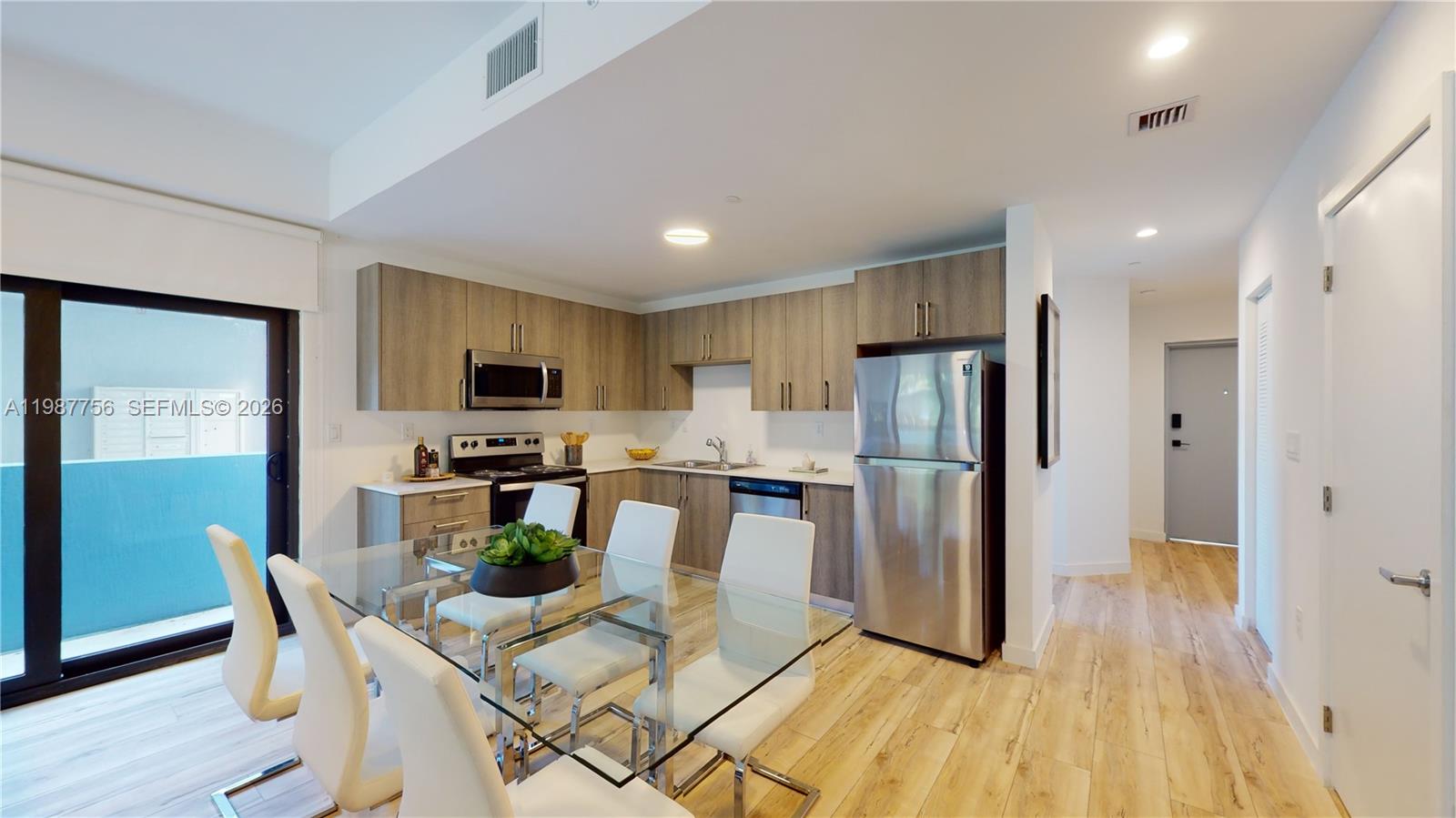 24705 Southwest 129th Avenue, Unit 110 Homestead, FL 33032 - Photo 1 of 33 a view of a dining room with furniture a kitchen and chandelier
