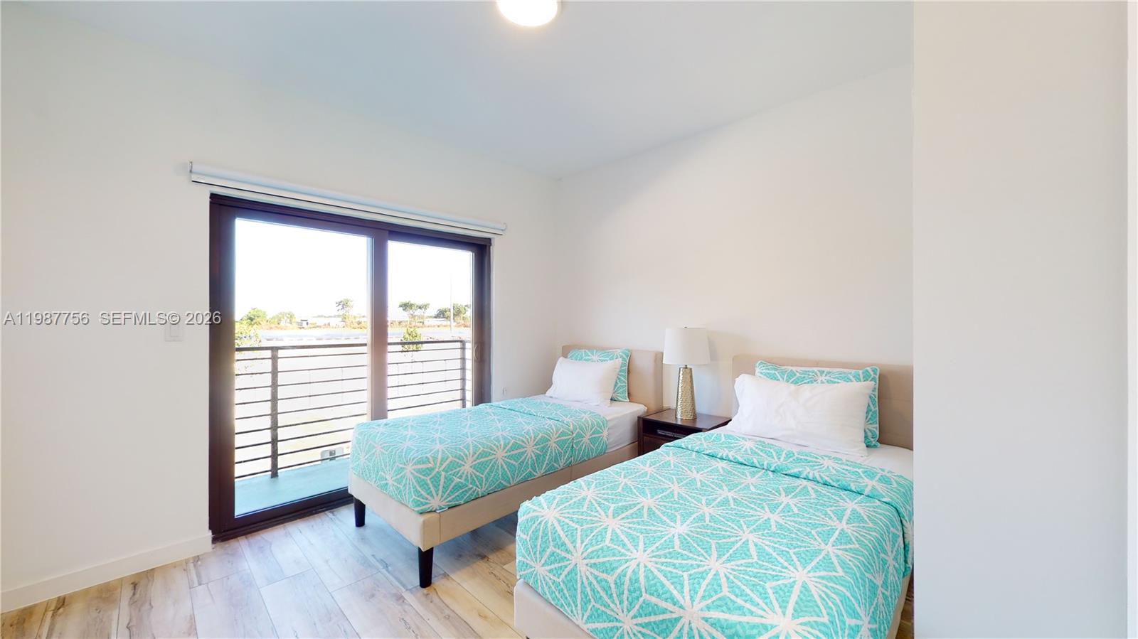 24705 Southwest 129th Avenue, Unit 110 Homestead, FL 33032 - Photo 27 of 33 a bedroom with two beds and a wooden floor