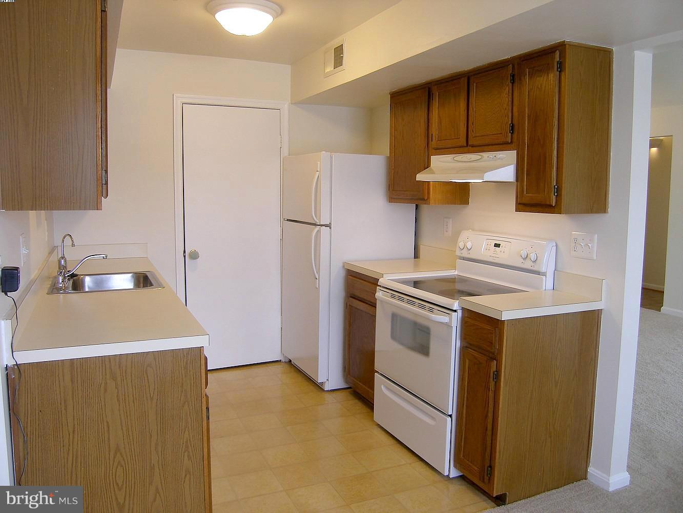 14906 McKisson Court, Unit B Silver Spring, MD 20906 - Photo 6 of 27 a kitchen with a sink cabinets and a refrigerator