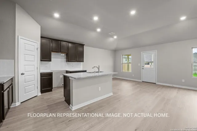 an empty room with windows and chandelier fan