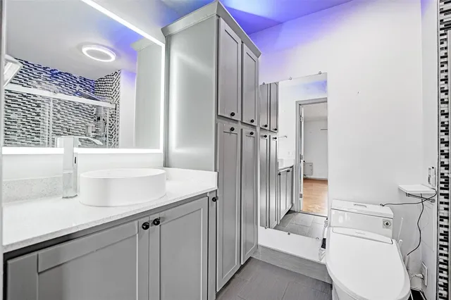 a bathroom with a sink a toilet and shower