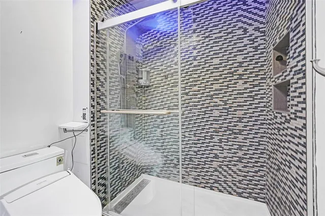 a bathroom with a toilet and a shower