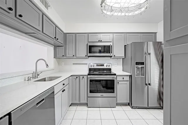 a kitchen with stainless steel appliances granite countertop a refrigerator sink and stove
