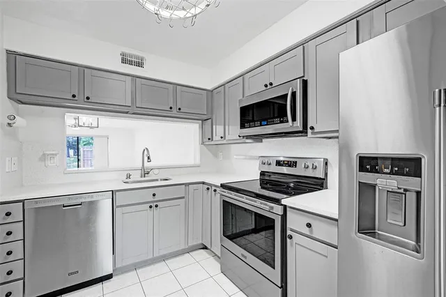 a kitchen with cabinets stainless steel appliances and sink