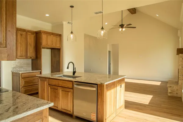 a kitchen with stainless steel appliances granite countertop a sink a stove and a refrigerator