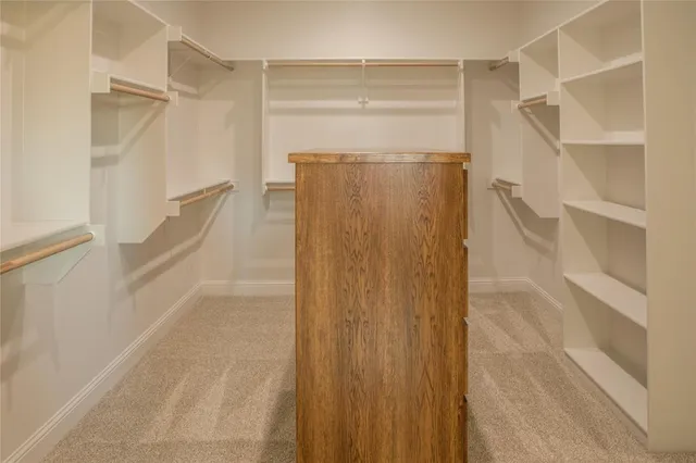 a view of walk in closet with empty racks