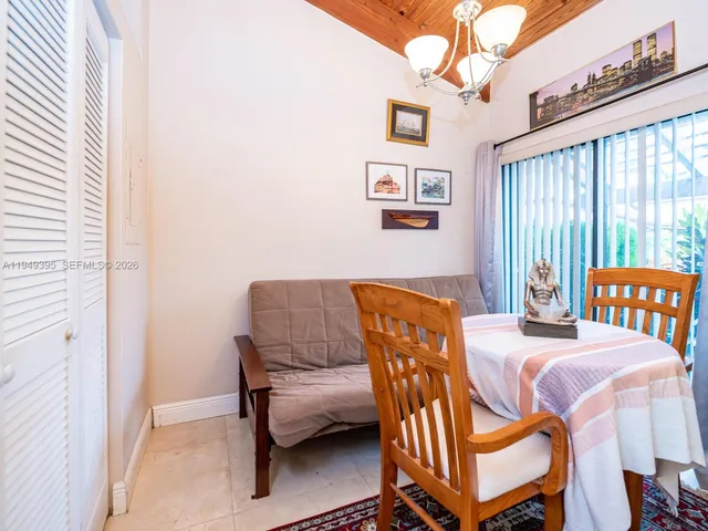 a kitchen with stainless steel appliances kitchen island granite countertop dining table chairs cabinets and a sink