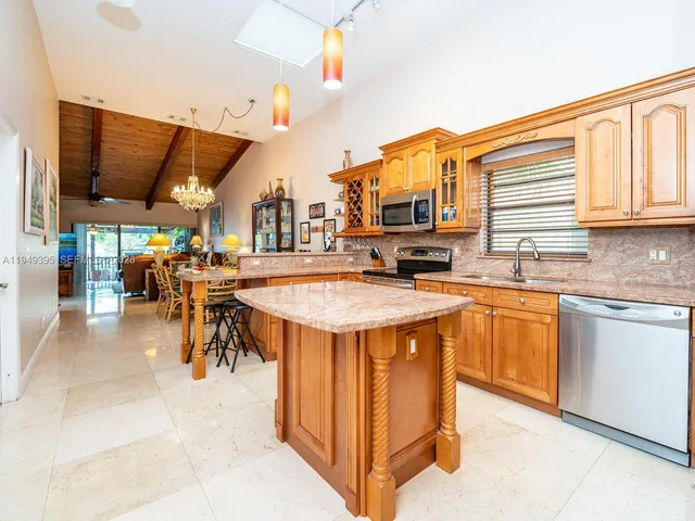 a dining room with furniture a chandelier and kitchen view