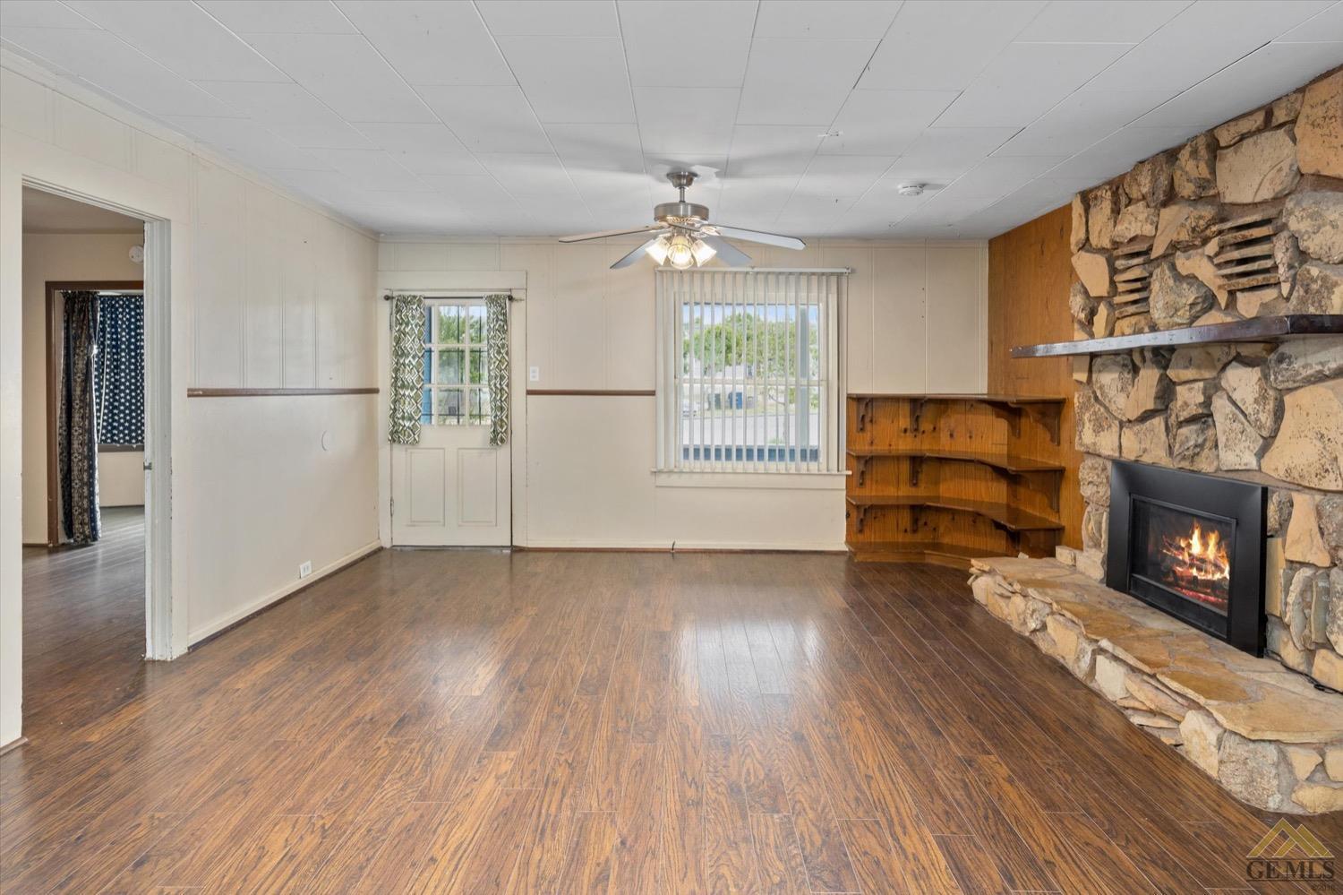 Undisclosed Address Taft, CA 93268 - Photo 7 of 21 an empty room with wooden floor fireplace and windows