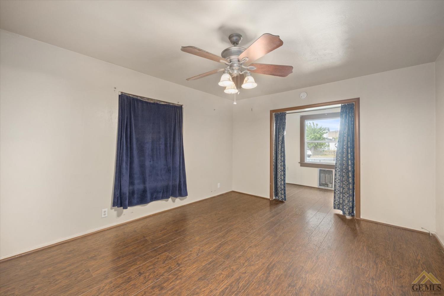 Undisclosed Address Taft, CA 93268 - Photo 10 of 21 an empty room with wooden floor chandelier fan and windows