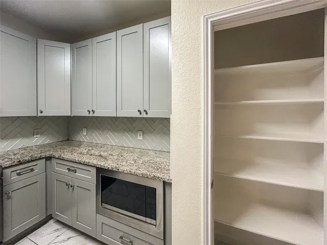 a kitchen with granite countertop cabinets stainless steel appliances and a counter space