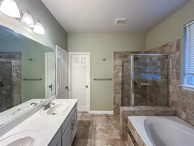a bathroom with a granite countertop tub sink and shower