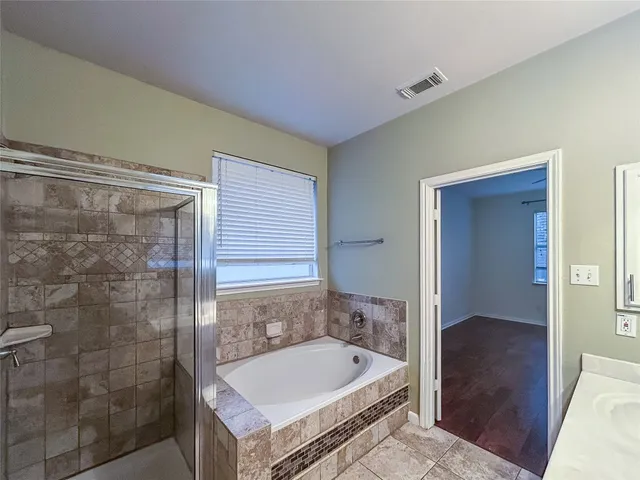 a bathroom with a tub shower and sink