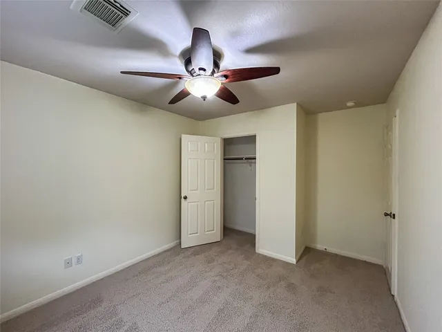 an empty room with chandelier fan