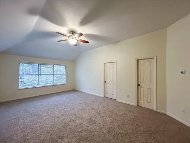 a view of empty room with a ceiling fan and window