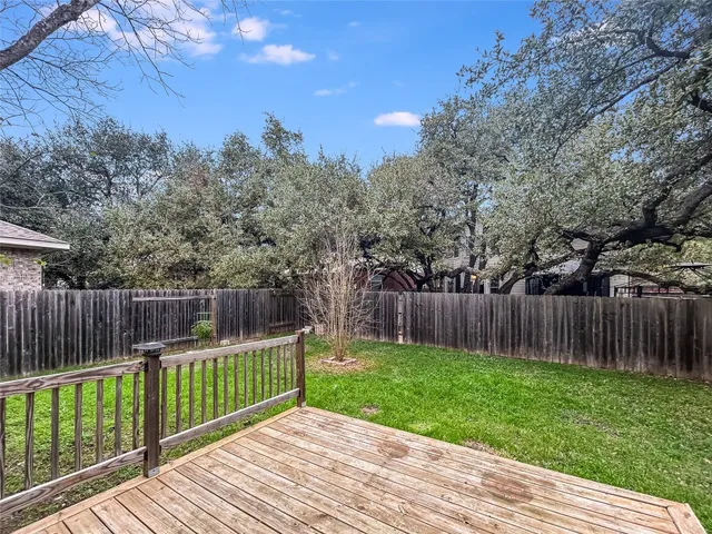 a view of backyard with wooden fence