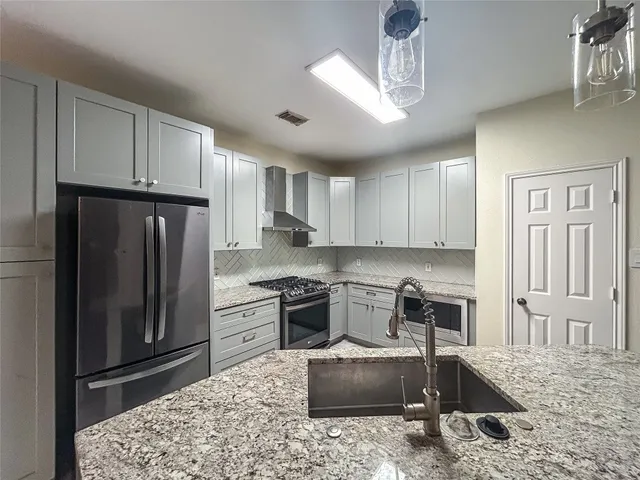 a kitchen with a stove a refrigerator and a sink
