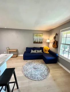 a living room with furniture a rug and a large window
