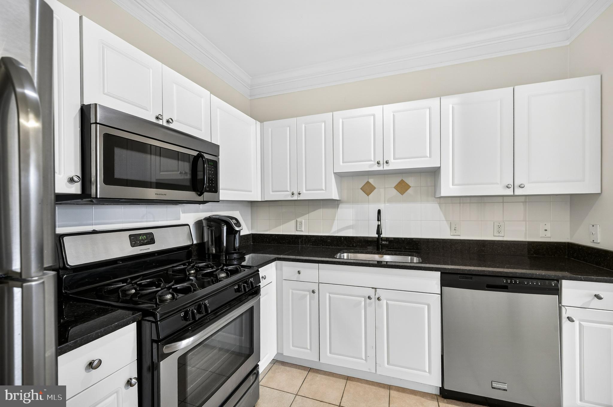 16 Granite Place, Unit 280 Gaithersburg, MD 20878 - Photo 16 of 47 a kitchen with white cabinets and black appliances