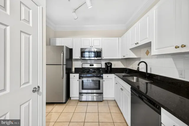 a kitchen with a refrigerator sink and white cabinets