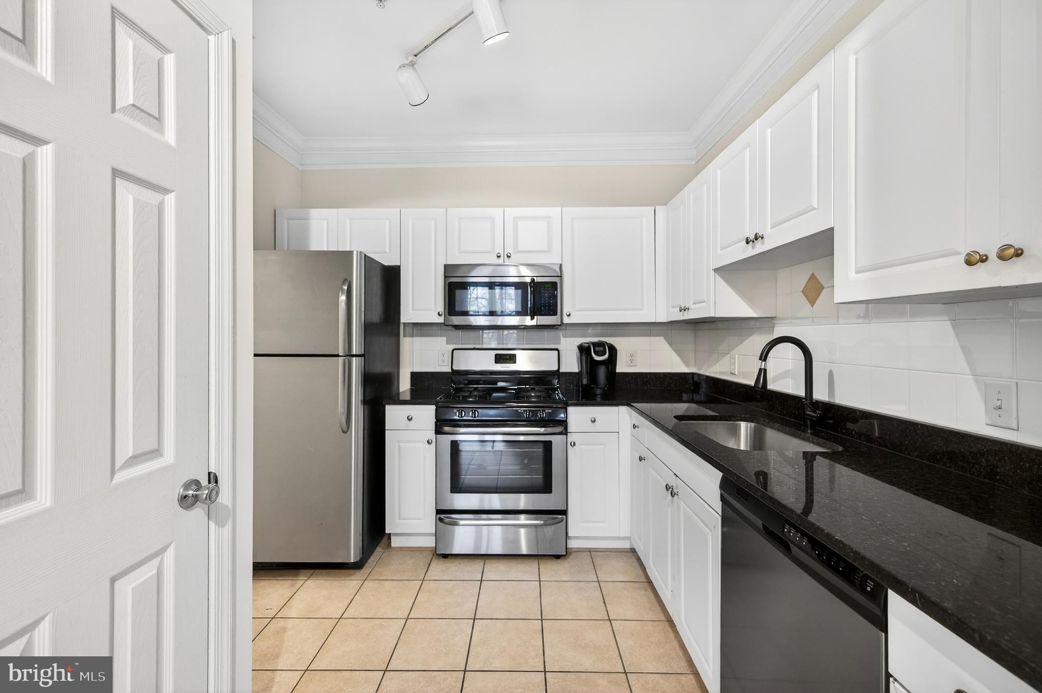 16 Granite Place, Unit 280 Gaithersburg, MD 20878 - Photo 17 of 47 a kitchen with a refrigerator sink and white cabinets