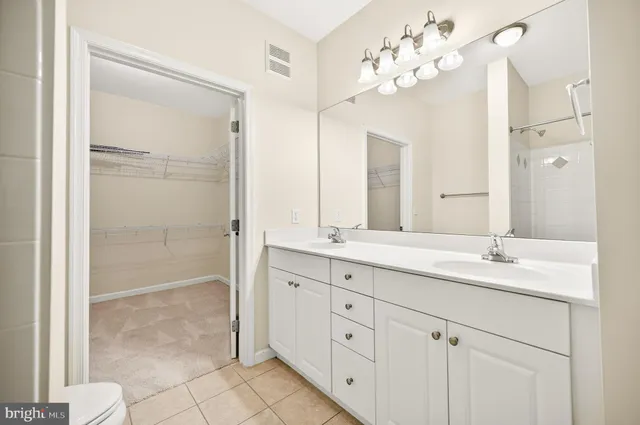 a bathroom with a granite countertop sink a mirror and a shower