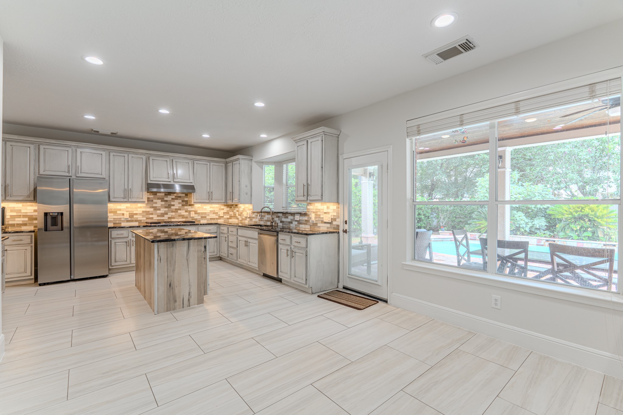 7 Stickley Court The Woodlands, TX 77382 - Photo 13 of 33 a kitchen with stainless steel appliances granite countertop a stove top oven a sink dishwasher and a refrigerator