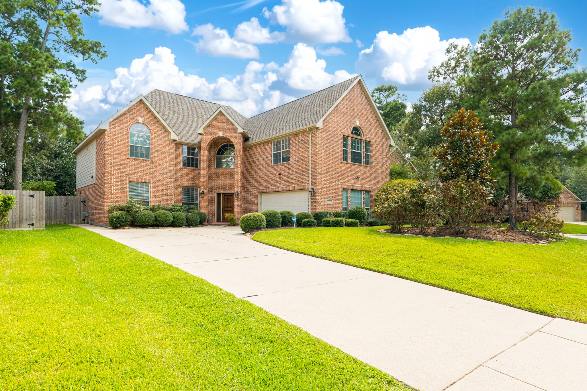7 Stickley Court The Woodlands, TX 77382 - Photo 2 of 33 a front view of a house with yard and garage