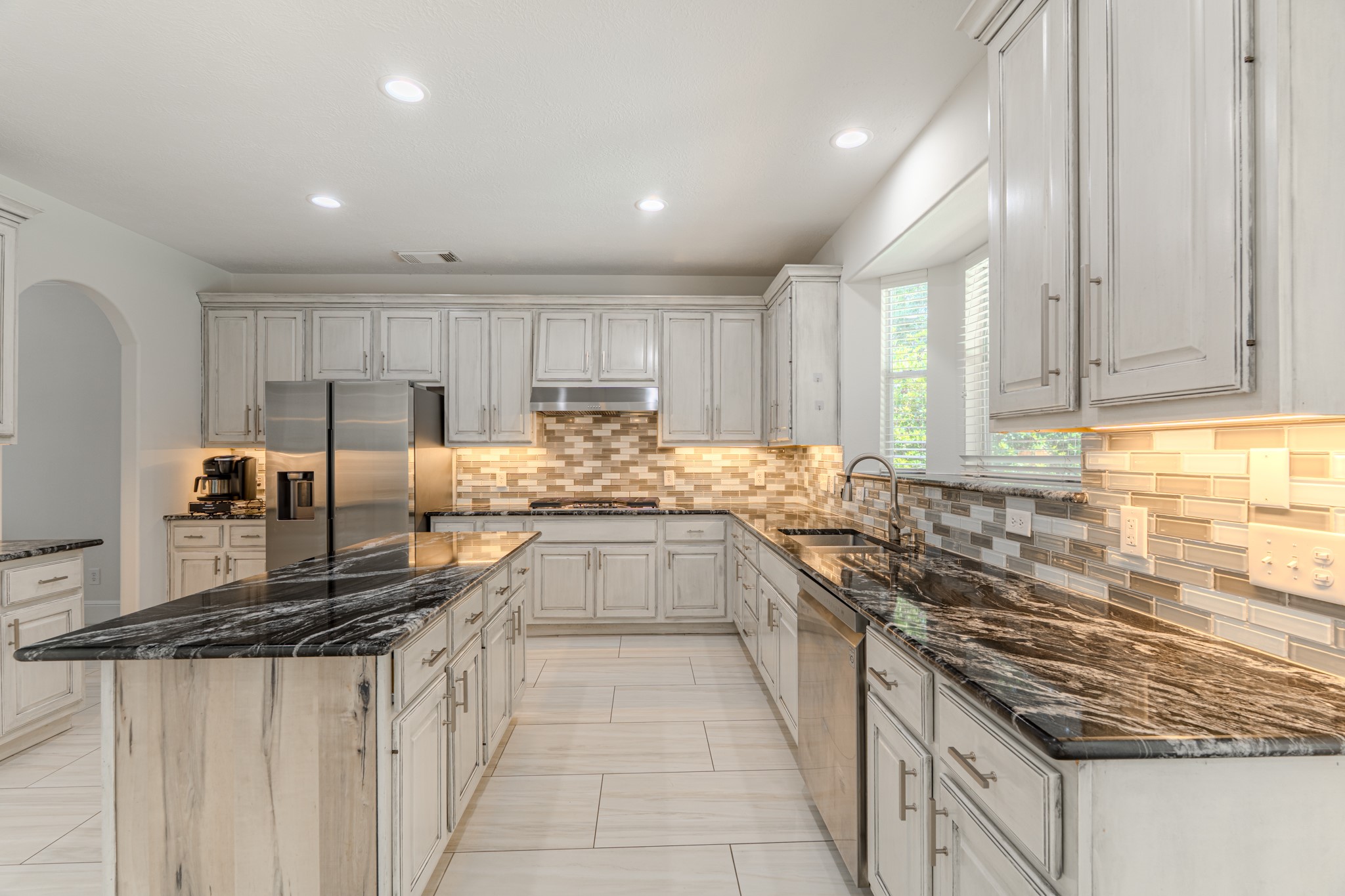 7 Stickley Court The Woodlands, TX 77382 - Photo 10 of 33 a large kitchen with granite countertop lots of counter space sink and stainless steel appliances