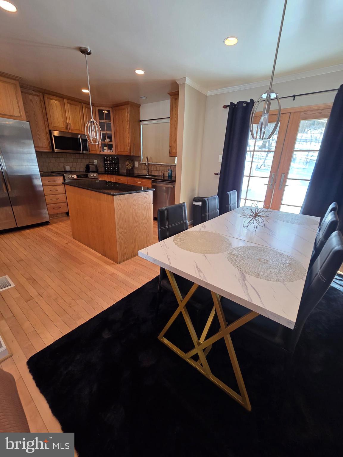 2122 Princess Anne Court Bowie, MD 20716 - Photo 12 of 37 a kitchen with stainless steel appliances kitchen island sink refrigerator dining table and chairs