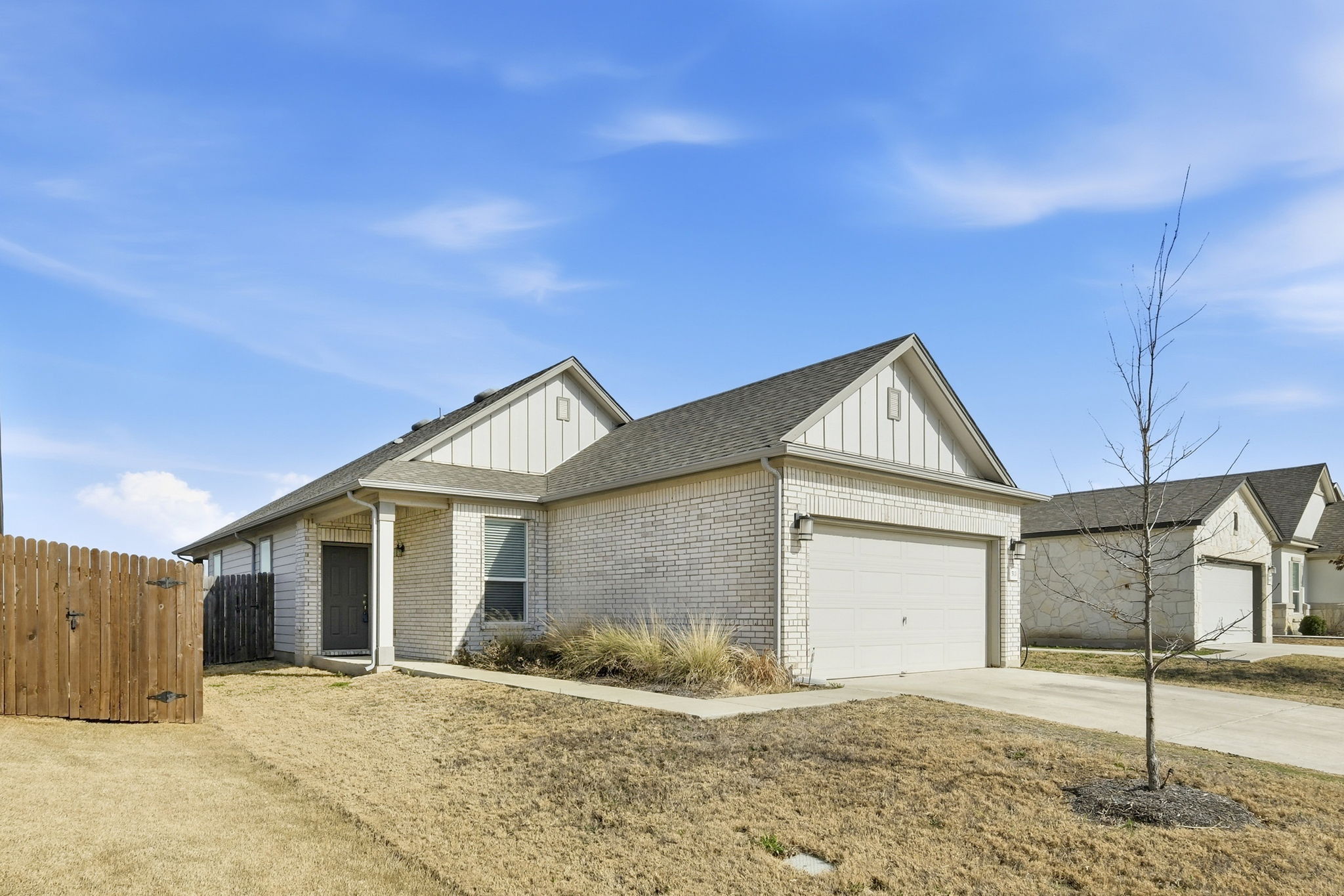 513 Thunder Valley Trail Georgetown, TX 78626 - Photo 1 of 15 View of front facade featuring board and batten siding, concrete driveway, brick siding, a garage, and roof with shingles